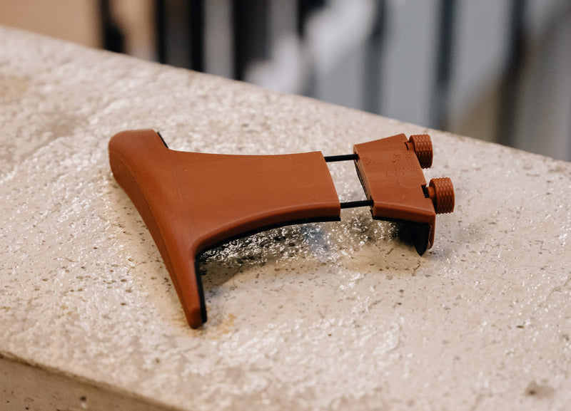 Actual brown D’accordo armrest, showing its printed surface and rounded support